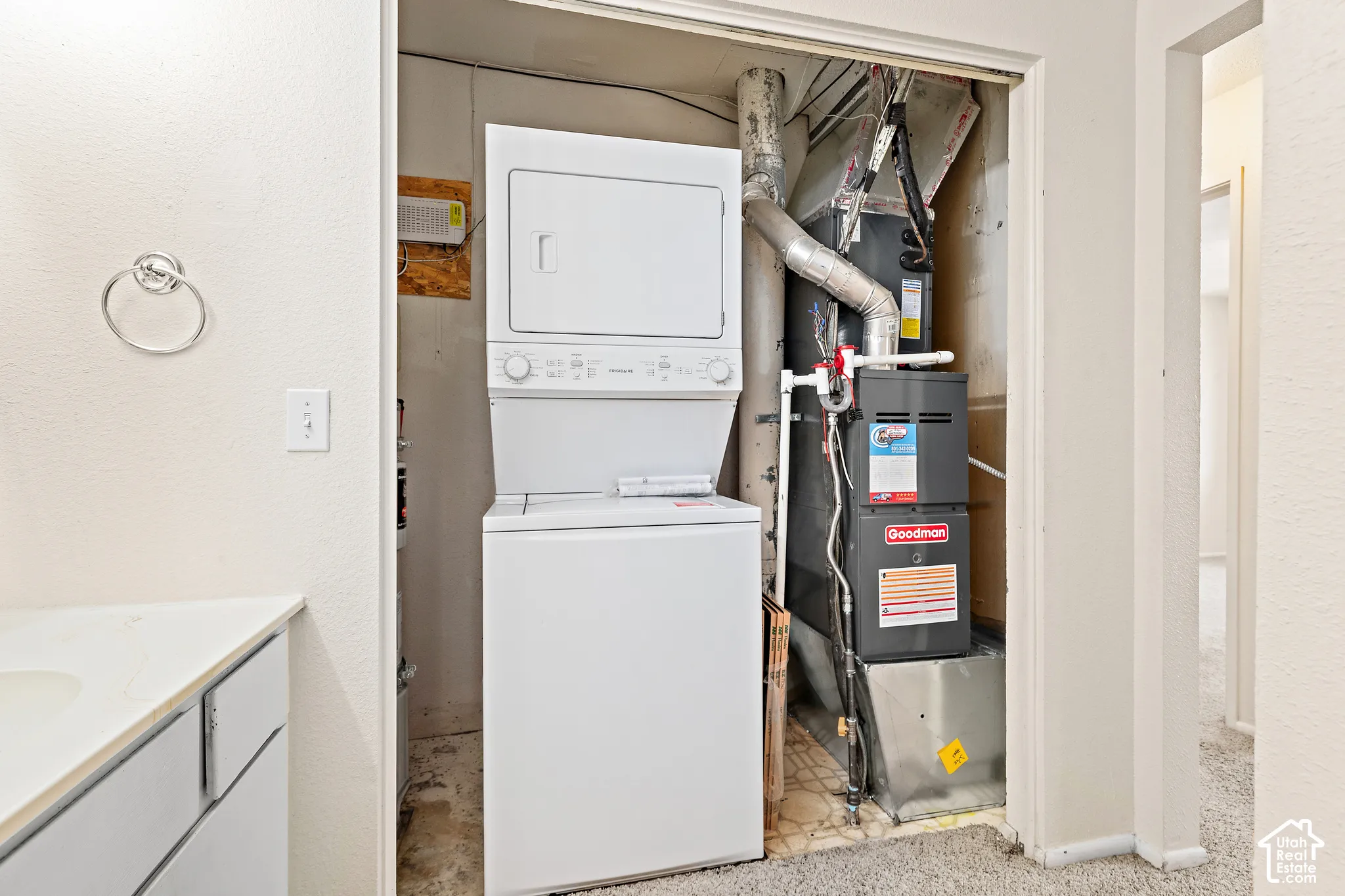 Stacked washer and dryer unit, and a furnace within a dedicated utility closet