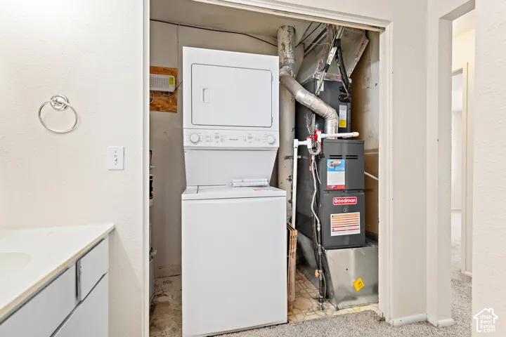 Stacked washer and dryer unit, and a furnace within a dedicated utility closet