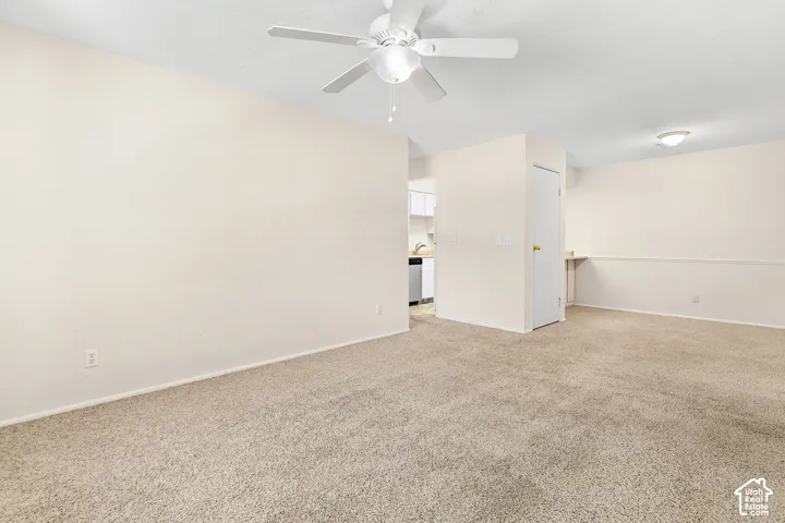Light-toned carpeting, ceiling fan with integrated lighting, recessed overhead lighting, and a built-in shelf