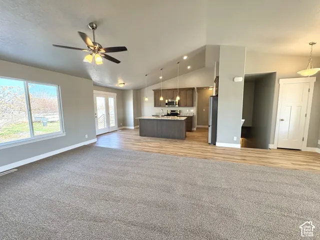 Vaulted ceilings, recessed lighting, wood-finish flooring, stainless steel appliances, and a ceiling fan