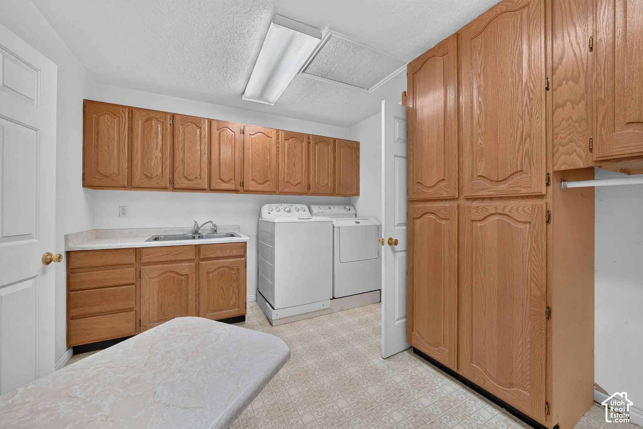 Laundry room off of the kitchen with lots of cabinetry.  Passes through to the primary bath.