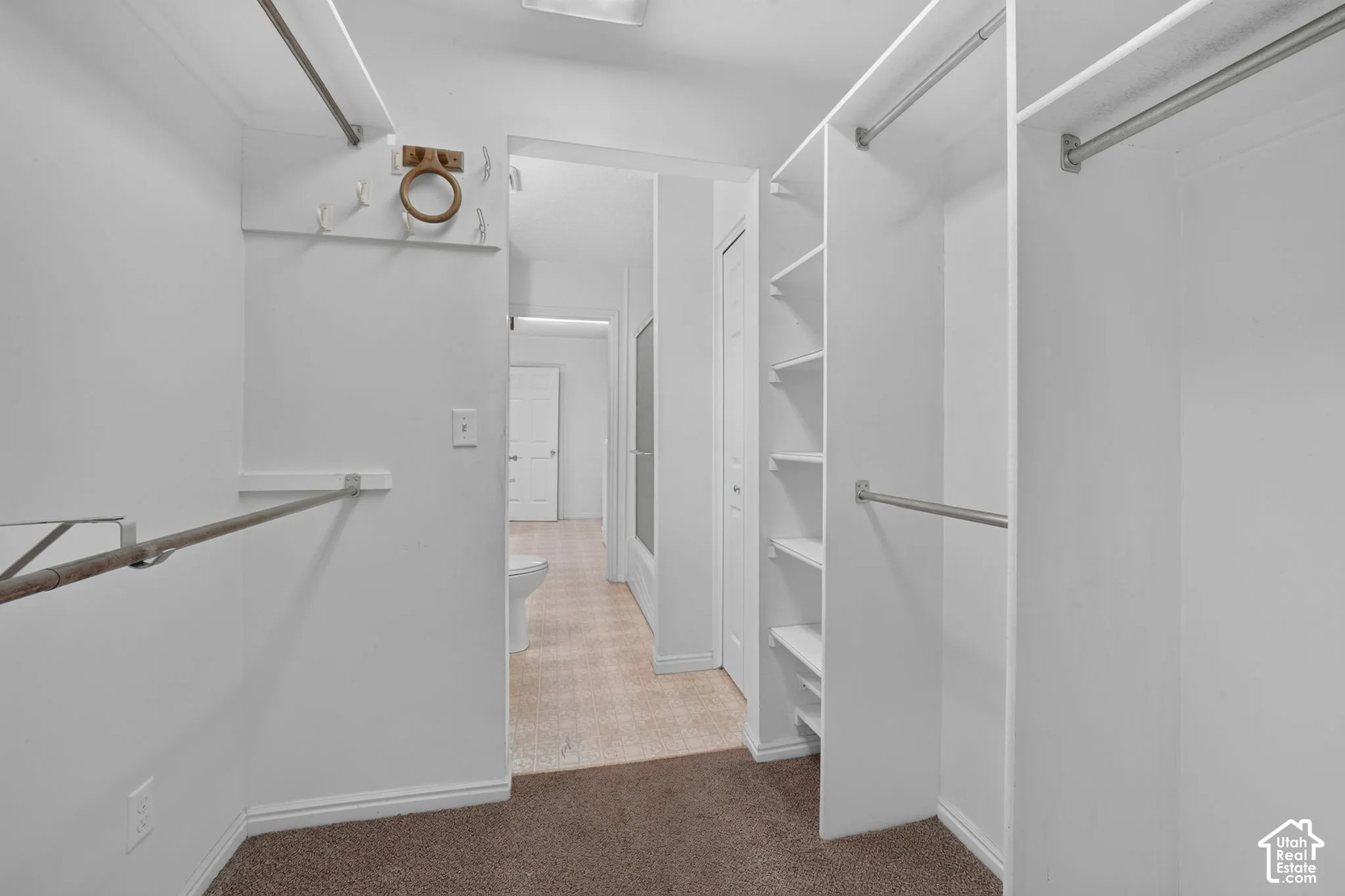 Primary Walk-in closet featuring built-in shelving and multiple hanging rods