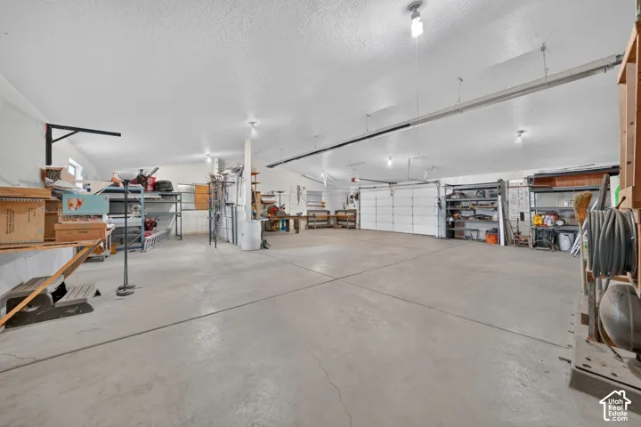 Expansive garage featuring, high ceilings, heating and concrete flooring