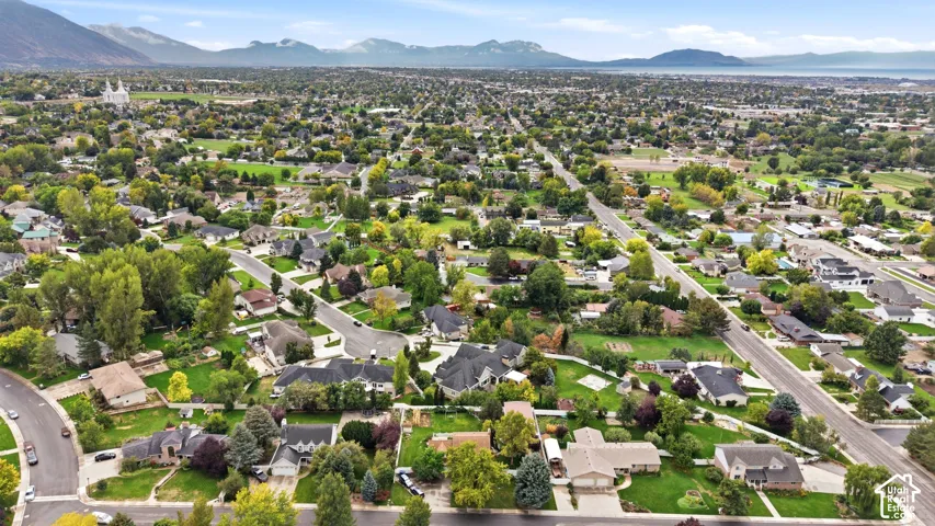Expansive residential area featuring established homes, mature trees, and mountainous scenery