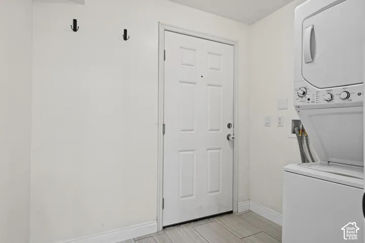 White paneled door, black wall-mounted hooks, and light-toned tile flooring