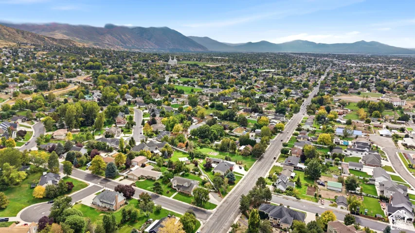 Aerial perspective highlighting a residential area with established neighborhoods, mature tree canopies, and a distinct mountain backdrop