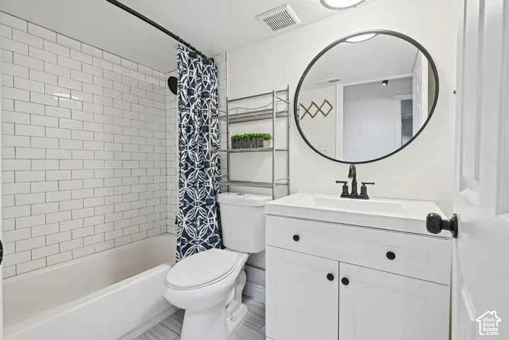 White subway tile shower surround, contemporary vanity with a contrasting black faucet, and a round black-framed mirror