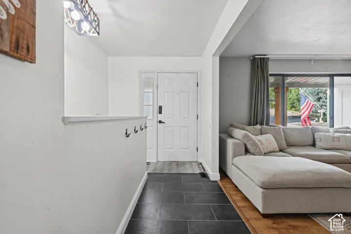 Entryway featuring dark slate tile flooring and a white front door with sidelight