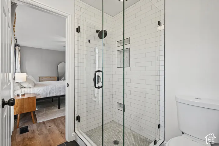 Glass-enclosed shower with white subway tile and matte black fixtures