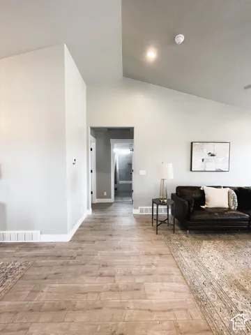 Vaulted ceilings, recessed lighting, and wood-finish flooring