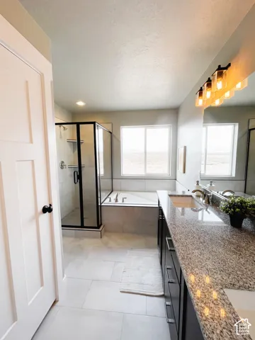 Double vanity with granite countertop, undermount sinks, and a contemporary light fixture
