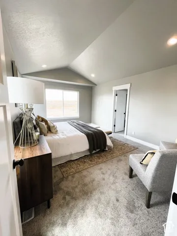 Vaulted ceiling with recessed lighting, light-colored carpeting, and a large window