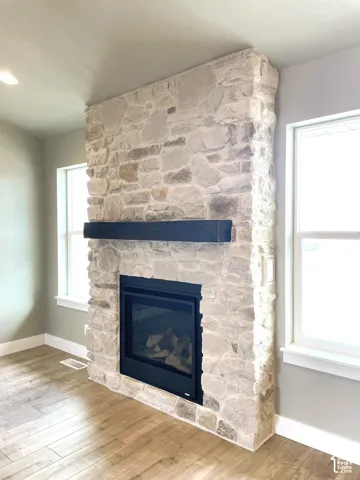 Stone-clad fireplace featuring a black mantel and integrated firebox