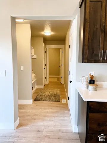 Wood-finish flooring throughout, with white baseboards, and overhead lighting fixtures