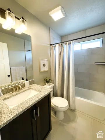Dark wood vanity with a light granite countertop and undermount sink