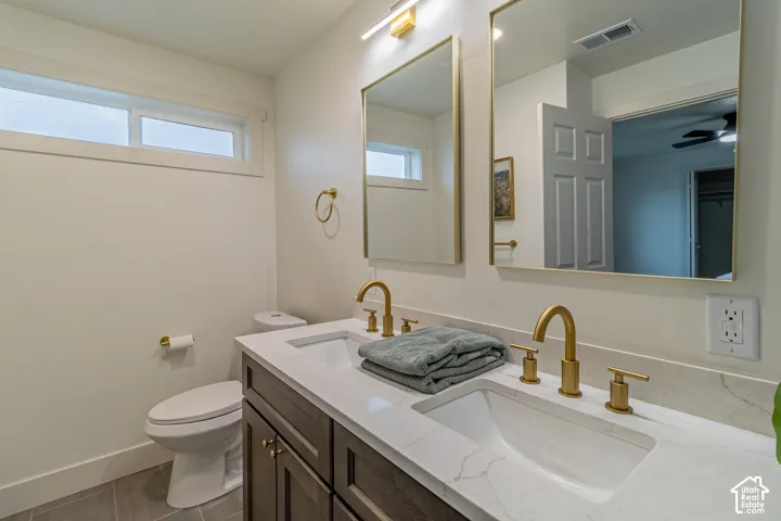 Dual vanity with integrated rectangular sinks, gold-finish fixtures, and a white countertop
