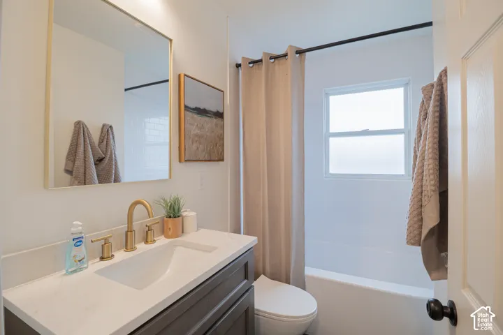 Vanity with a light-colored countertop and gold-toned faucet