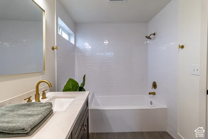 White subway tile surround with a built-in bathtub and brass fixtures