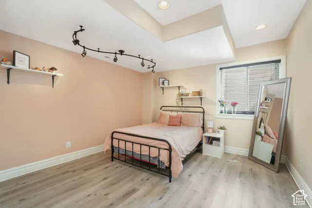 Recessed ceiling lights, wood-finish flooring, track lighting fixture, built-in shelving, and window with blinds