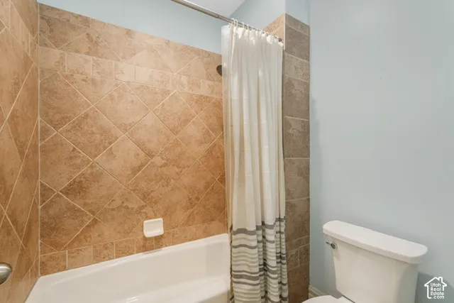 Bathtub with tile surround featuring a diagonal pattern and decorative border