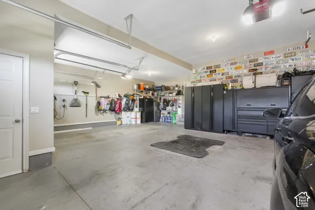 Concrete flooring, overhead garage door system, wall-mounted storage solutions, recessed lighting