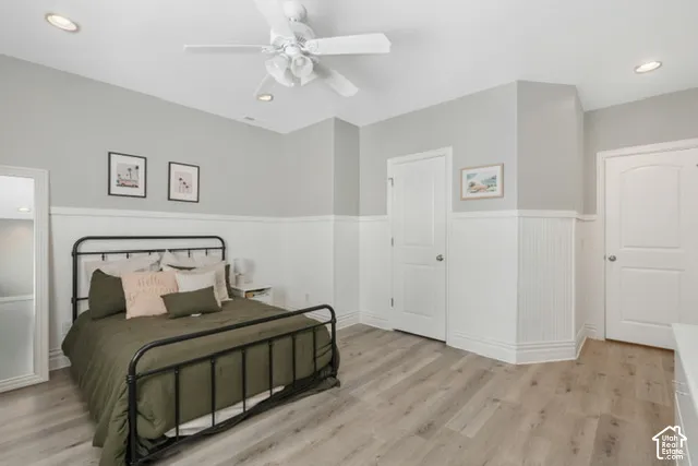 Vaulted ceiling with recessed lighting, wood-finish flooring, beadboard wainscoting, and white paneled doors