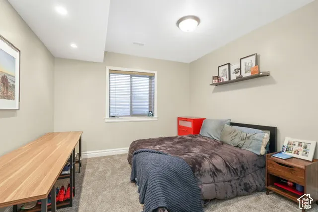 Recessed lighting, wood-finish desk, wall-mounted shelving, overhead lighting, and window with blinds
