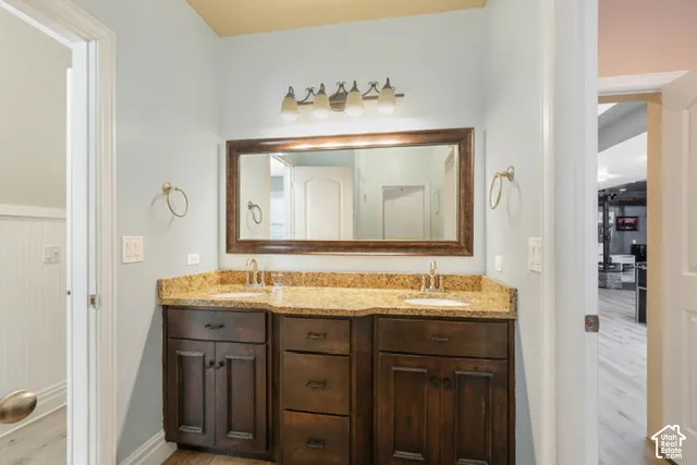 Double vanity with a composite countertop and integrated sinks, illuminated by a four-light fixture