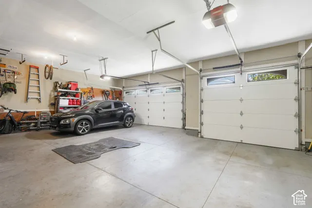 Two-car garage featuring a concrete floor, two white paneled garage doors, and overhead lighting