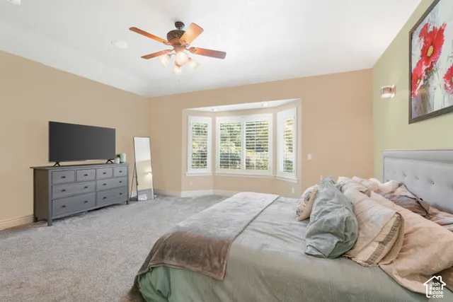 Recessed ceiling, ceiling fan with integrated lighting, bay window with plantation shutters, wall sconces, wall-to-wall carpeting