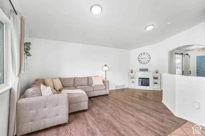 Wood-finish flooring, white walls, and recessed lighting