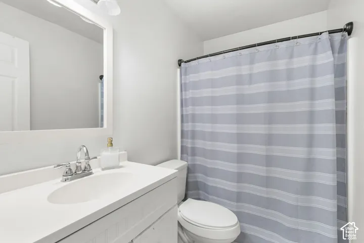 Single vanity with an integrated sink, polished chrome faucet, and overhead lighting