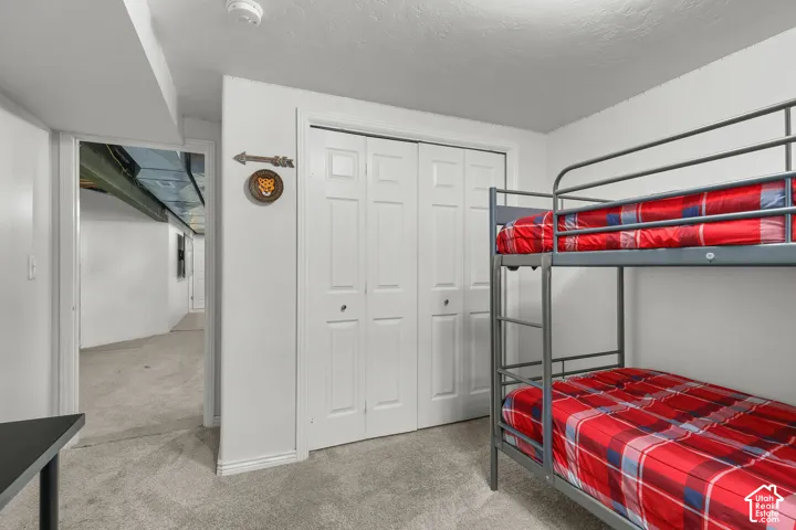 Carpeted room featuring a ceiling-mounted light fixture and bi-fold closet doors