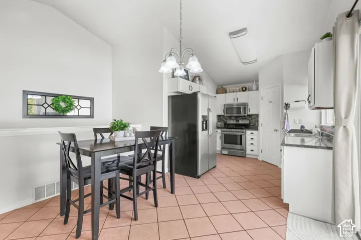 Kitchen with stainless steel appliances, granite-look countertops, and tile flooring