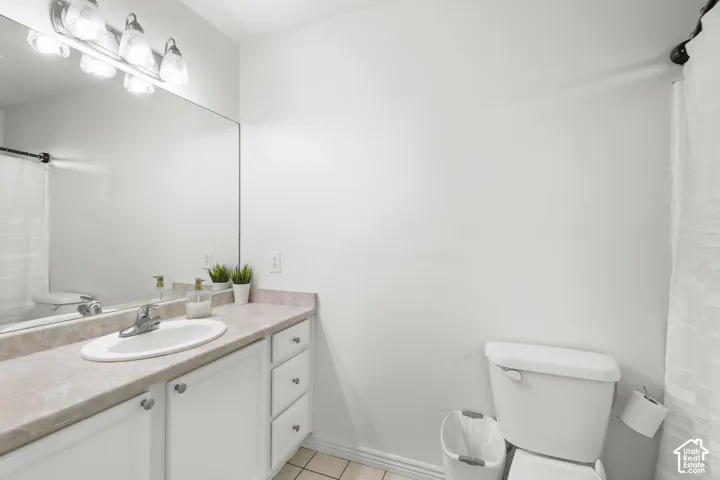 White vanity with integrated sink, chrome faucet, and expansive wall-mounted mirror