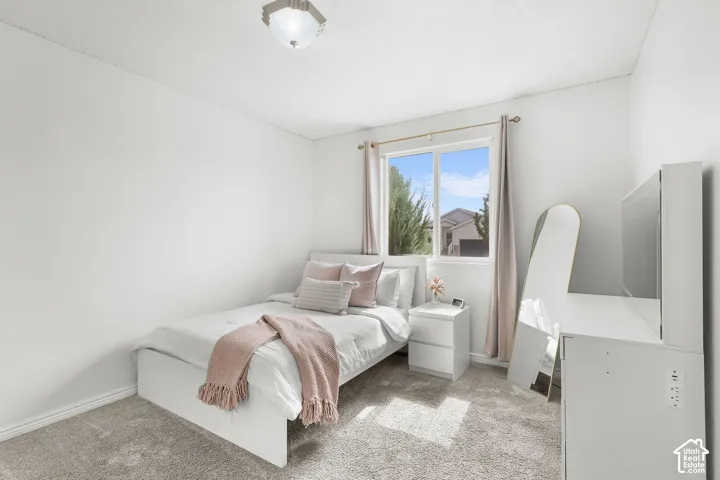 Bright interior with light gray carpeting, white walls, and a window with white trim