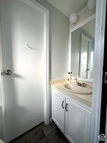 Vanity with integrated sink, dual-door cabinetry, and wall-mounted mirror