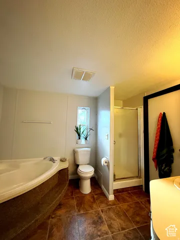 Corner soaking tub, enclosed shower, and ceramic tile flooring