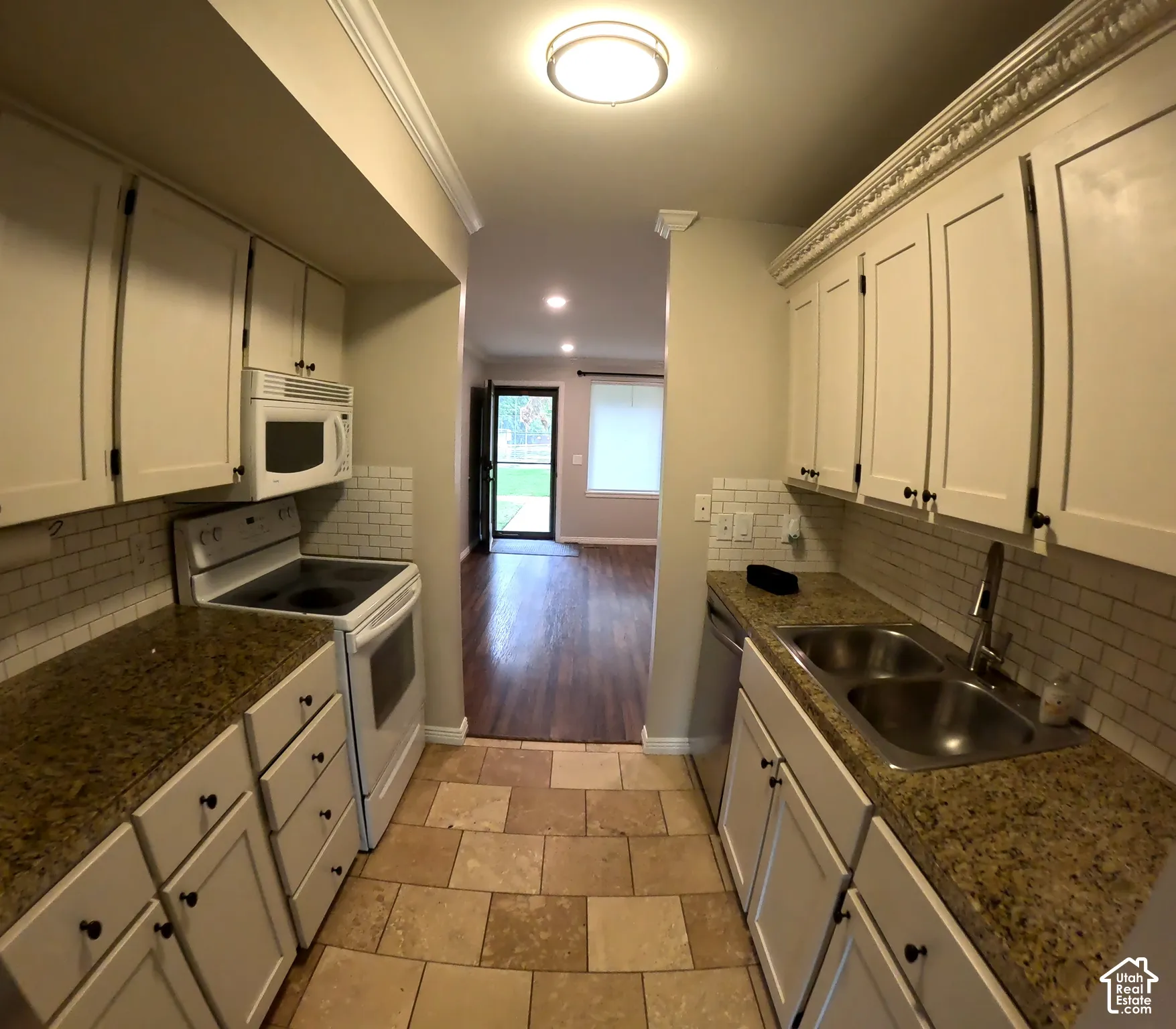 Kitchen featuring white cabinetry, stone countertops, white subway tile backsplash, and tile flooring