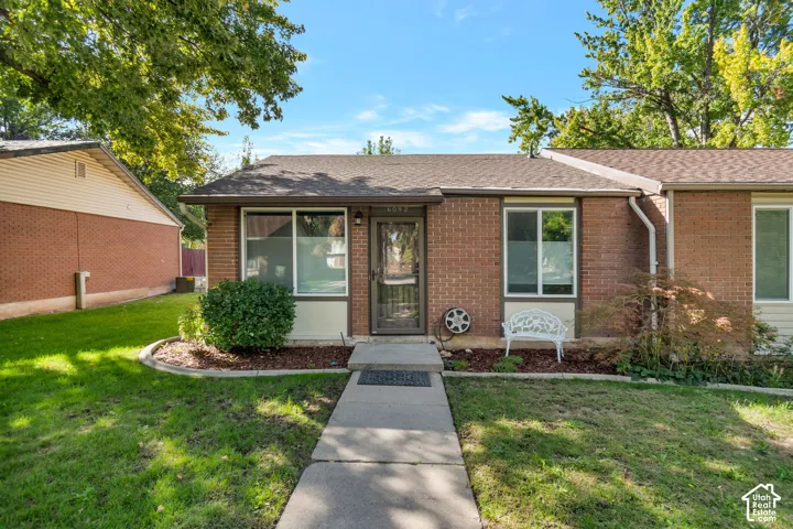 Brick exterior with a gabled roof and established landscaping.