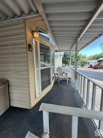 Covered porch with a metal roof and a wall-mounted exterior light fixture