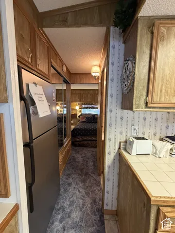 Hallway with wood-finish paneling, mirrored closet doors, and patterned carpeting