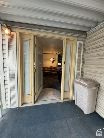 Entry with double doors featuring sidelights, exterior wall lantern, and a tiled interior floor