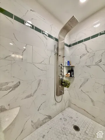 Tiled shower with a rainfall shower system, integrated shelving, and a built-in bench