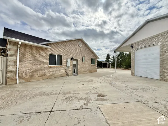 Brick exterior, attached garage, detached garage, concrete driveway, and mature landscaping