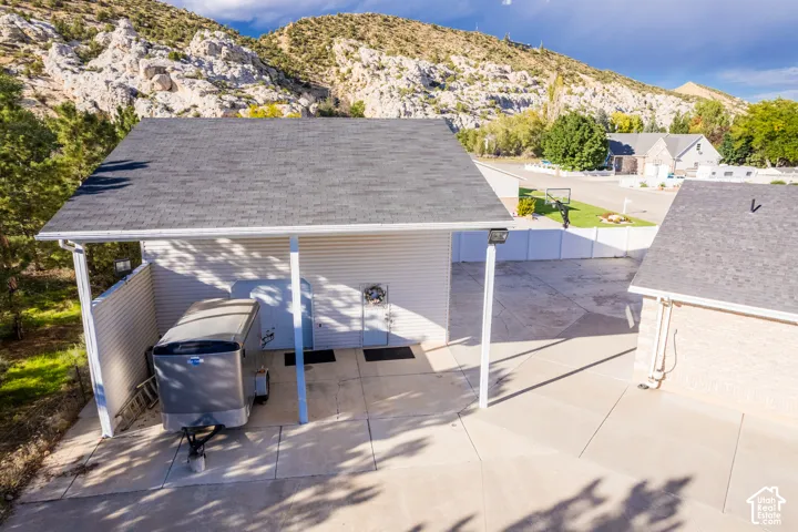 Carport with concrete slab, white siding, and an asphalt shingle roof