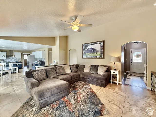 Open-concept living area with tile flooring and a ceiling fan