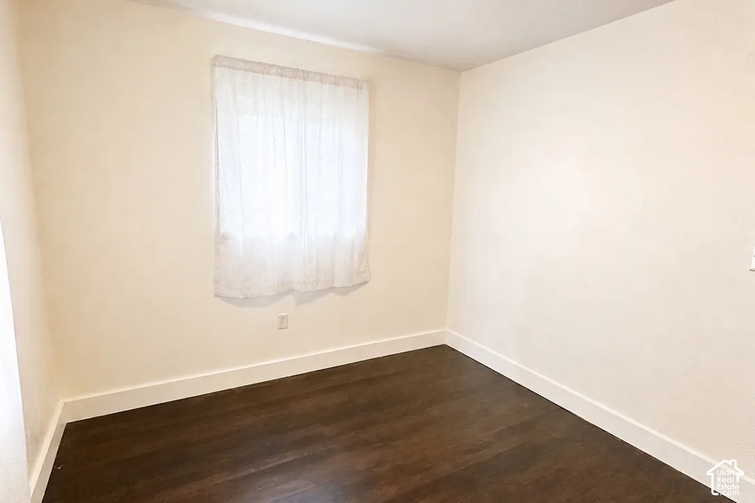 Dark wood-finish flooring with white baseboards