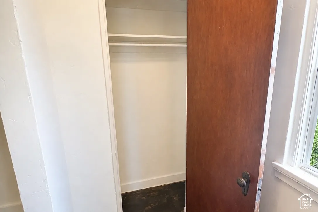 Closet with a single hanging rod, upper shelf, wood-finish door, and traditional door hardware