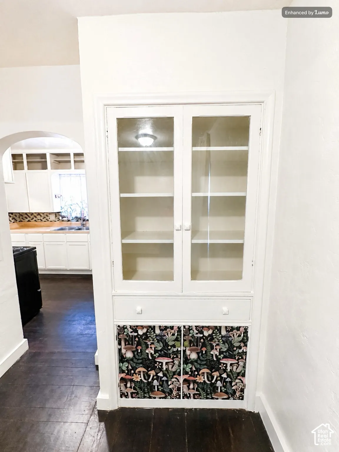 Built-in cabinetry featuring glass-front upper doors, a central drawer, and lower cabinet storage